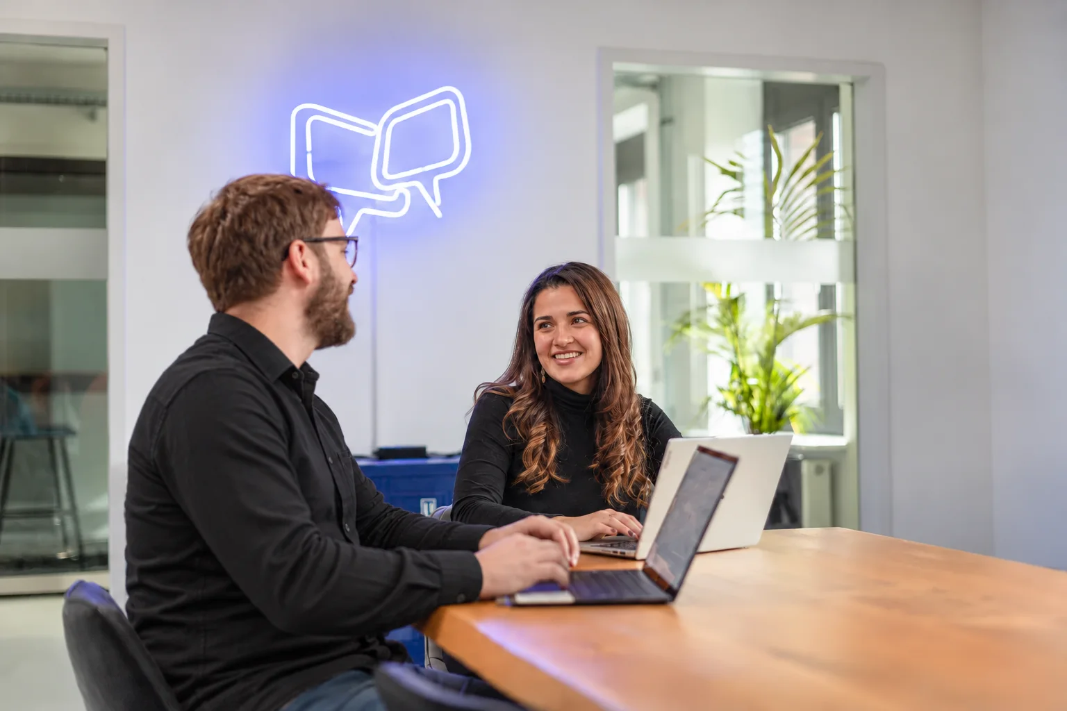 KI-bearbeitete Büroszene mit Maria Knipping und Danny Trapp vor dem OnlineDialog-Sprechblasenlogo